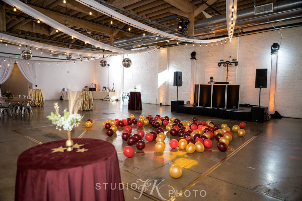A DJ and cocktail tables set up with balloons all over the dance floor at a holiday event at SKYLIGHT in Denver, Colorado