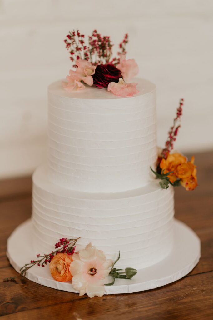 A beautiful two-tiered wedding cake with small florals at SKYLIGHT in Denver, CO.