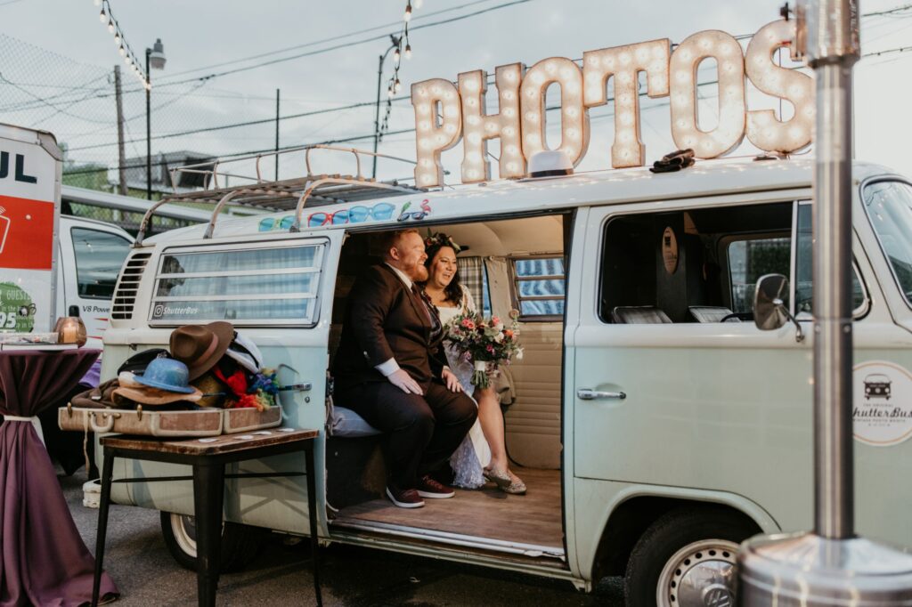 A bride and groom in a vintage photo bus outside at SKYLIGHT in Denver, CO.