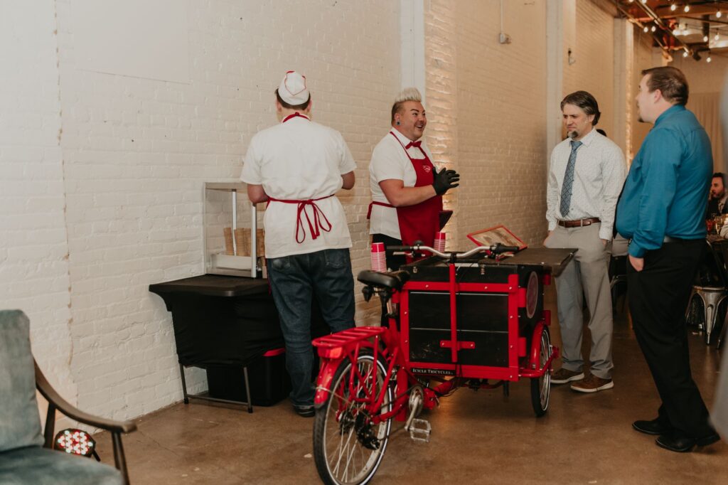 Two men serving ice cream from a mobile bicycle cart at SKYLIGHT in Denver, CO.