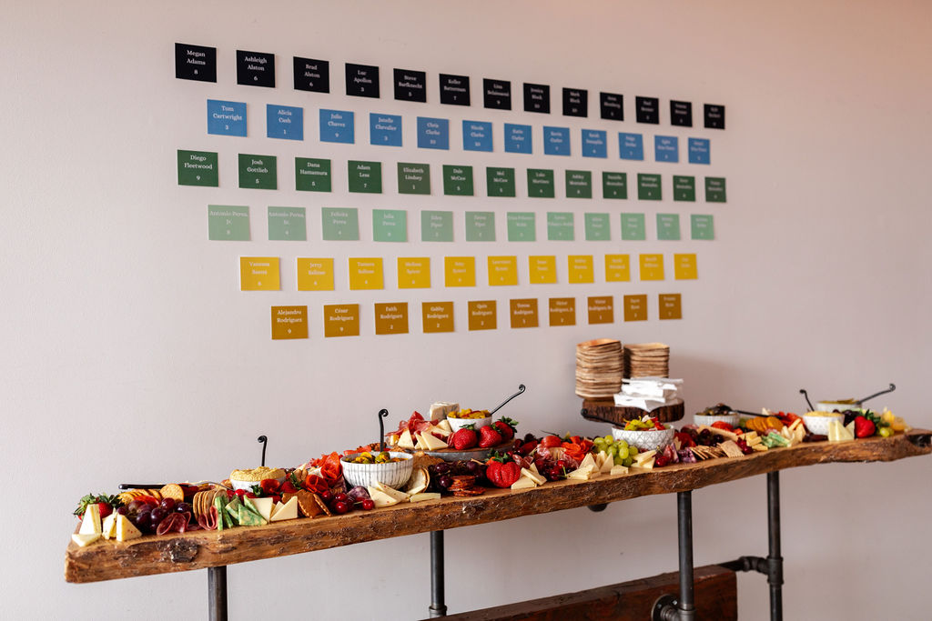 Colorful seating chart and grazing table at a wedding at SKYLIGHT in Denver