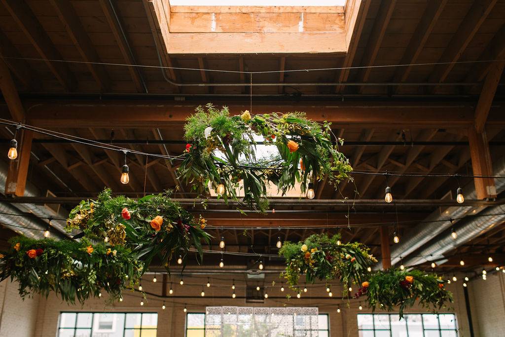 Greenery and bright floral chandeliers at SKYLIGHT in Denver, Colorado.