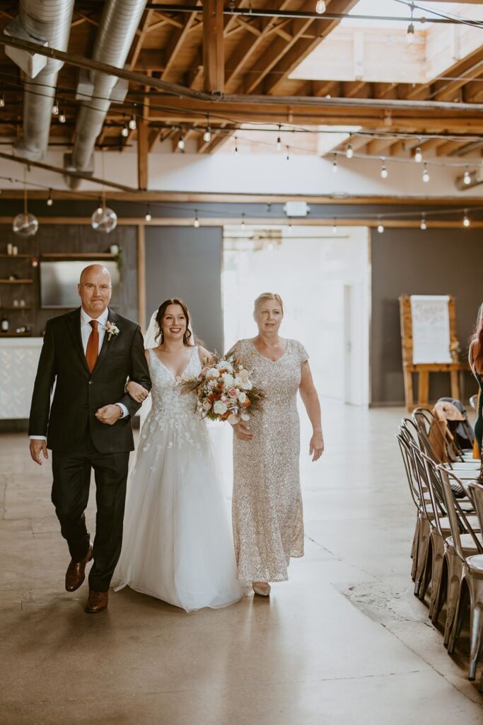 A bride and their family walking down the aisle at SKYLIGHT in Denver, Colorado.