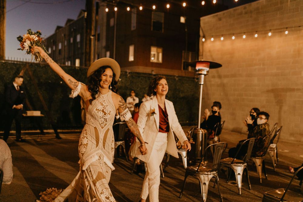 Brides walking down the aisle outside at SKYLIGHT