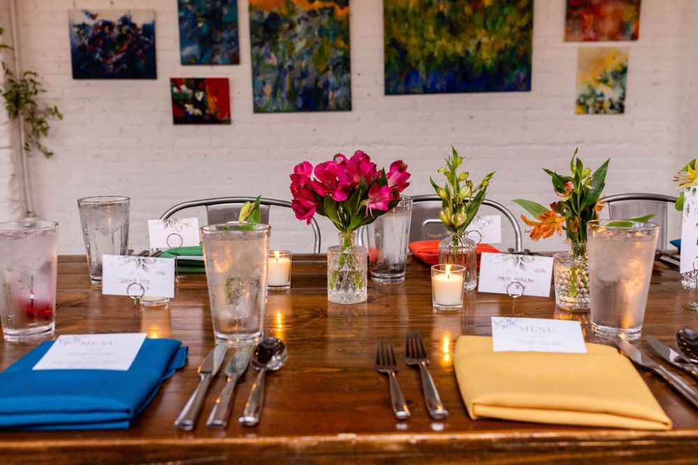 Place setting at a Denver wedding with flowers and colorful art