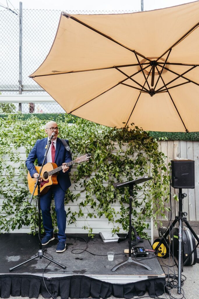 Friend of couple singing during cocktail hour