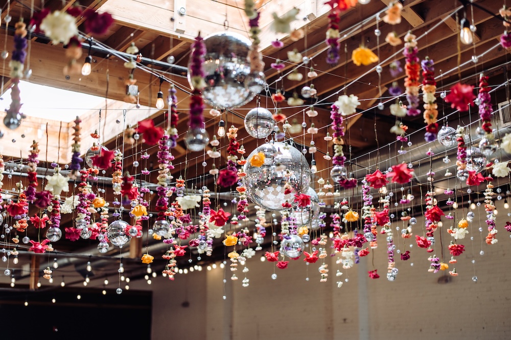 Disco balls and flowers hanging from the rafters at SKYLIGHT