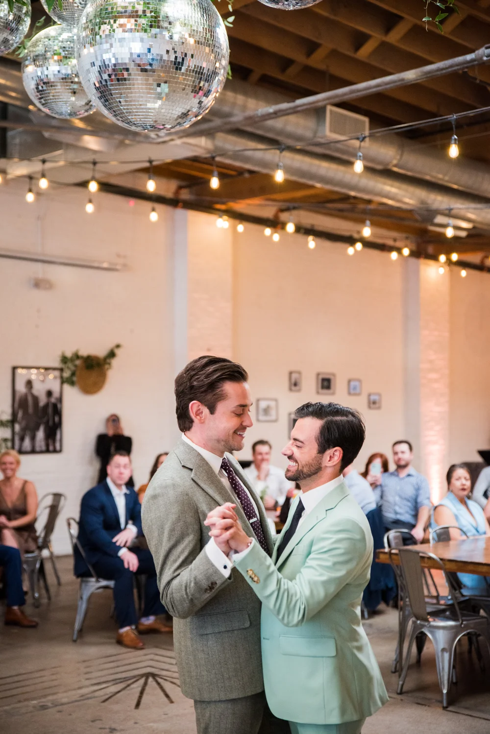Two grooms dancing under the skylights at SKYLIGHT