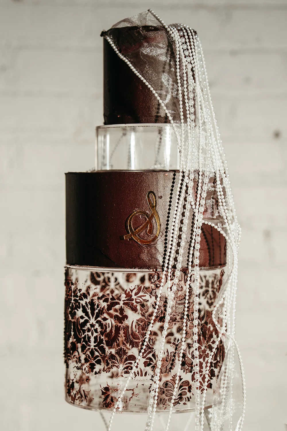 Tiered wedding cake with maroon and white layers at SKYLIGHT Denver wedding venue