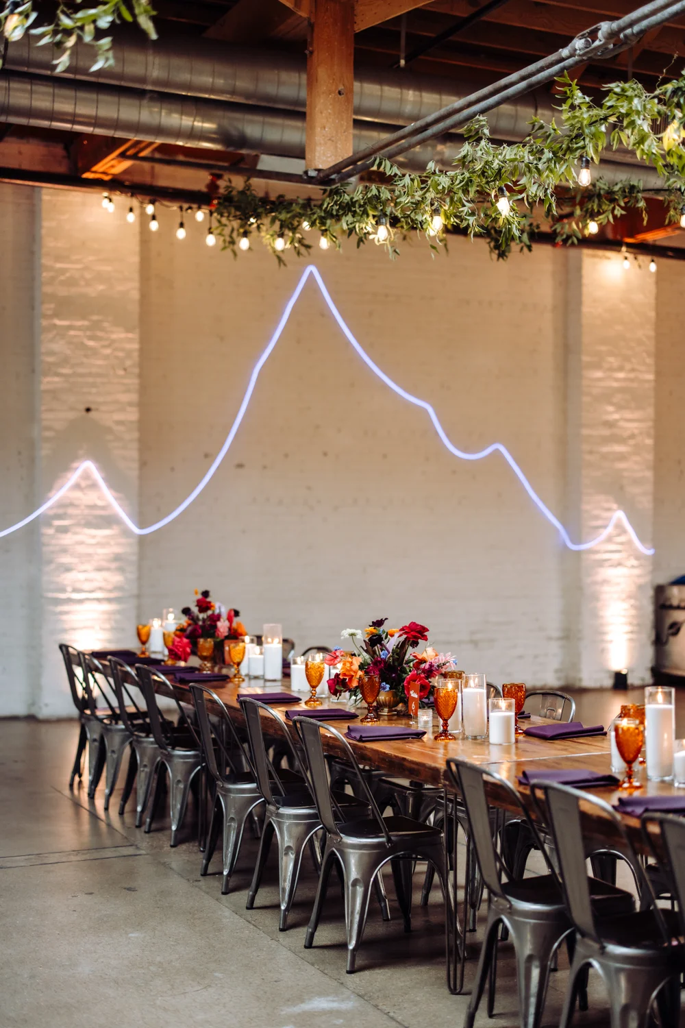 Colorful wedding reception at SKYLIGHT Denver featuring a neon “rave mountain” along the wall, perfect for a nontraditional wedding
