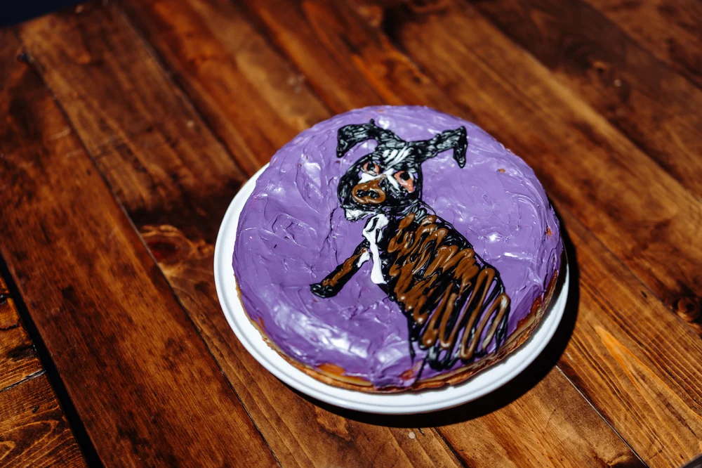 Large donut cake with a dog illustration served at a SKYLIGHT Denver wedding, a fun and personalized dessert for a nontraditional wedding celebration