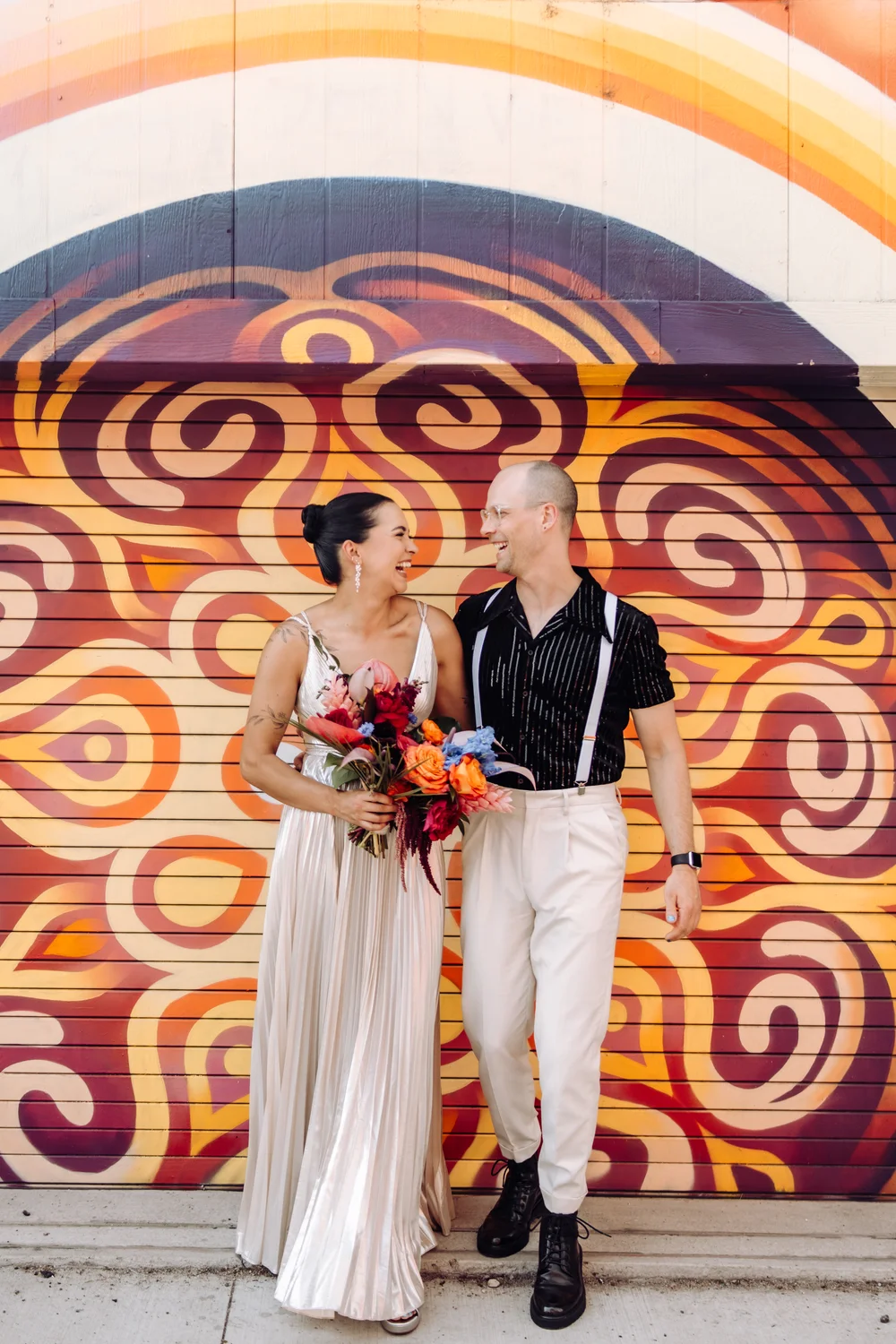 Bride and groom at a colorful mural in Denver’s Santa Fe Arts District, perfect for a nontraditional wedding photoshoot