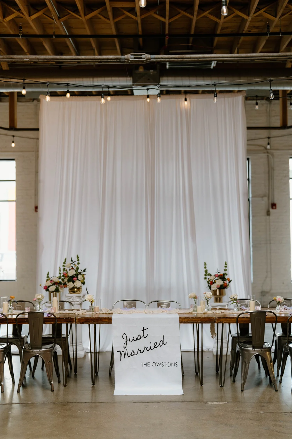 Wedding sweetheart table at SKYLIGHT Denver with “Just Married” sign