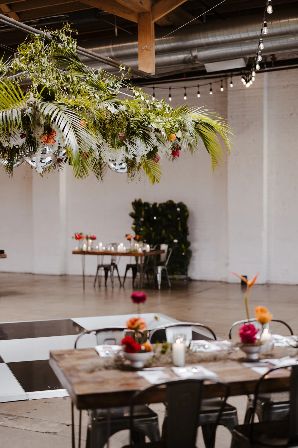 Wedding reception at SKYLIGHT Denver with black and white dance floor and large hanging floral installation