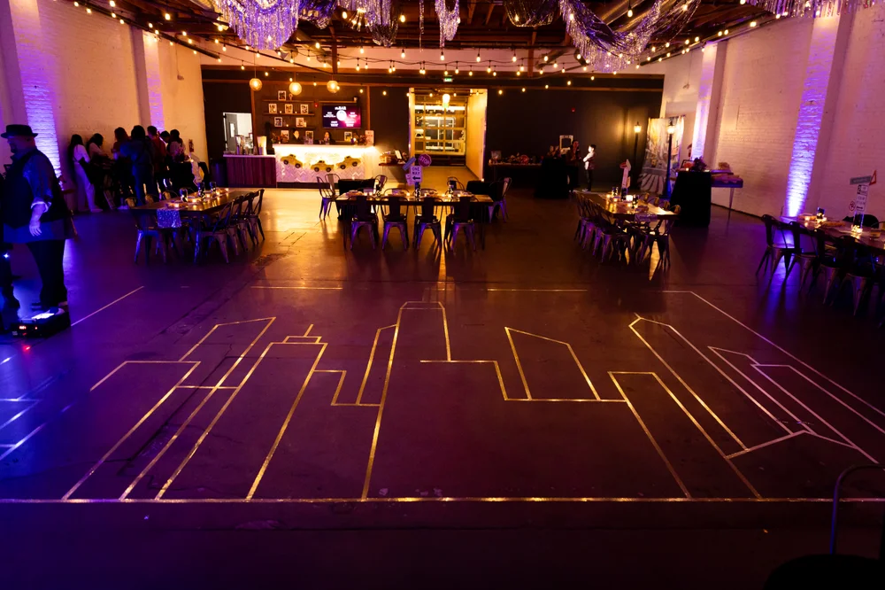 NYC-themed bat mitzvah at SKYLIGHT Denver with gold mylar tape design on the floor outlining New York City