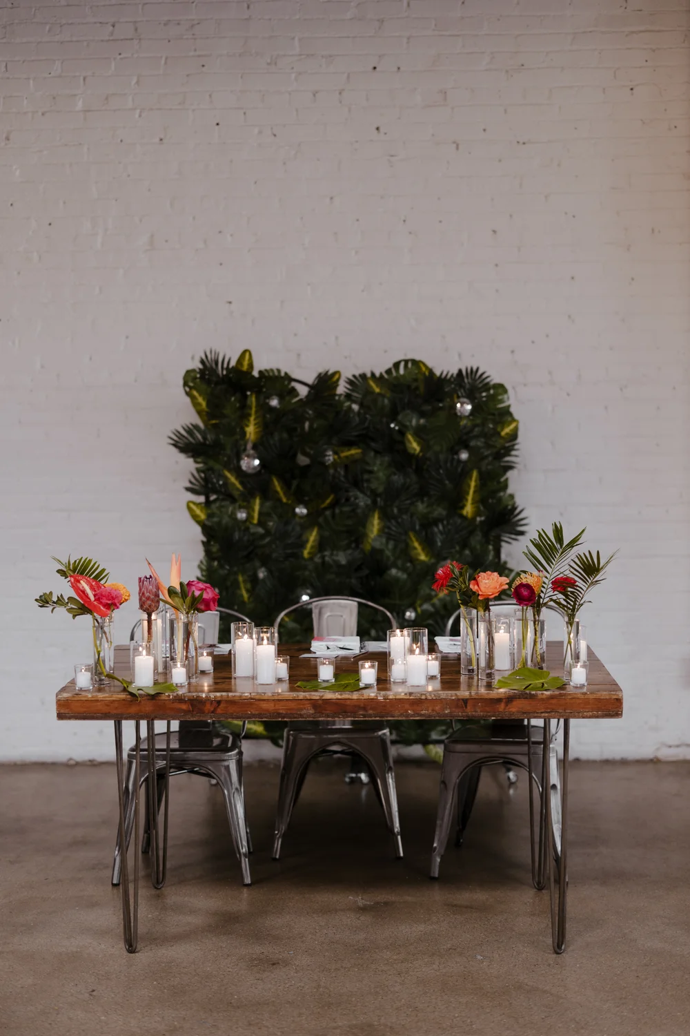 Sweetheart table with hedge wall backdrop and bright florals at SKYLIGHT in Denver, CO